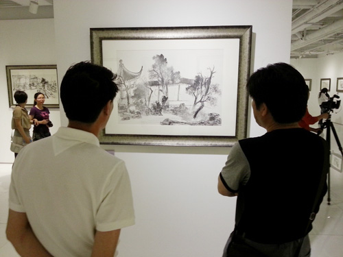 5月21日下午,两名观众在北京雍和家园艺术空间欣赏中央美术学院姚鸣京教授学生的山水写生作品。 摄影:杨铁虎