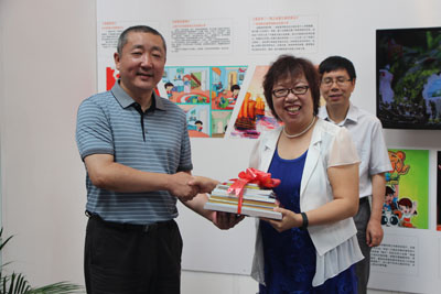  文化部文化产业司副司长高政（左）向人大附小赠送动漫作品