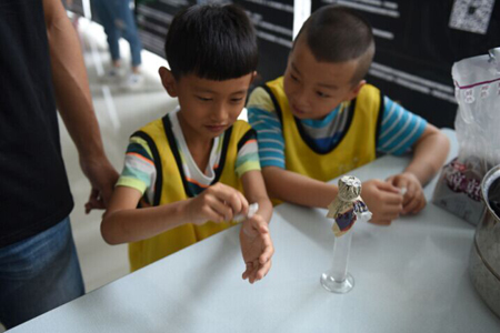 孩子在濾取面包液前用酒精給手消毒   人民網記者馮粒攝