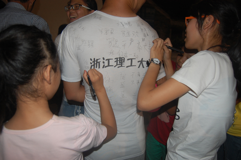 浙江理工大学曙光在行动协会赴天台进行了为期20天的支教。图为文艺汇演上，孩子们在衣服上签名留下纪念。