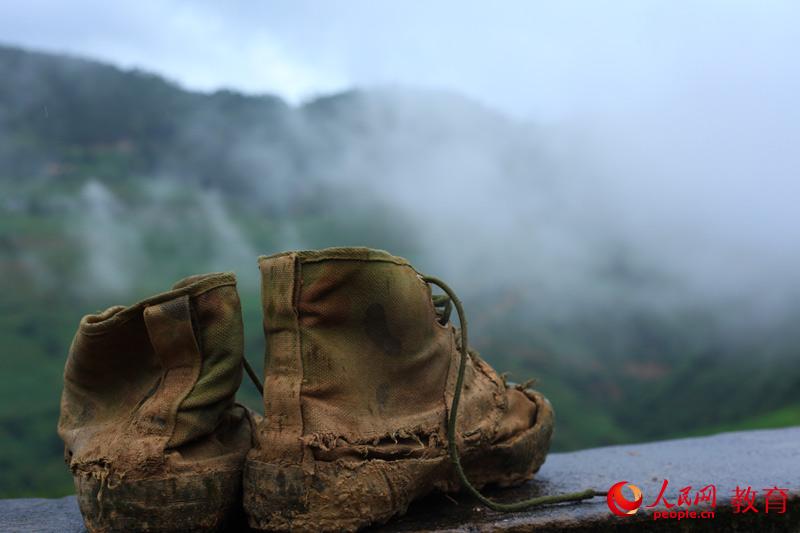 每天要在泥泞的山路上走好几个来回，脚上的布鞋已经沾满泥泞。