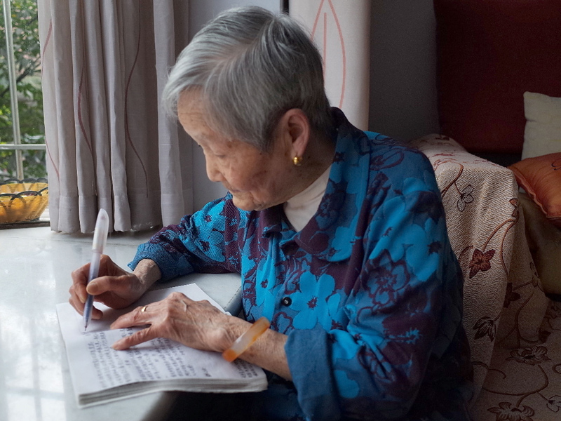 89岁老人匡体道在窗前写字。 