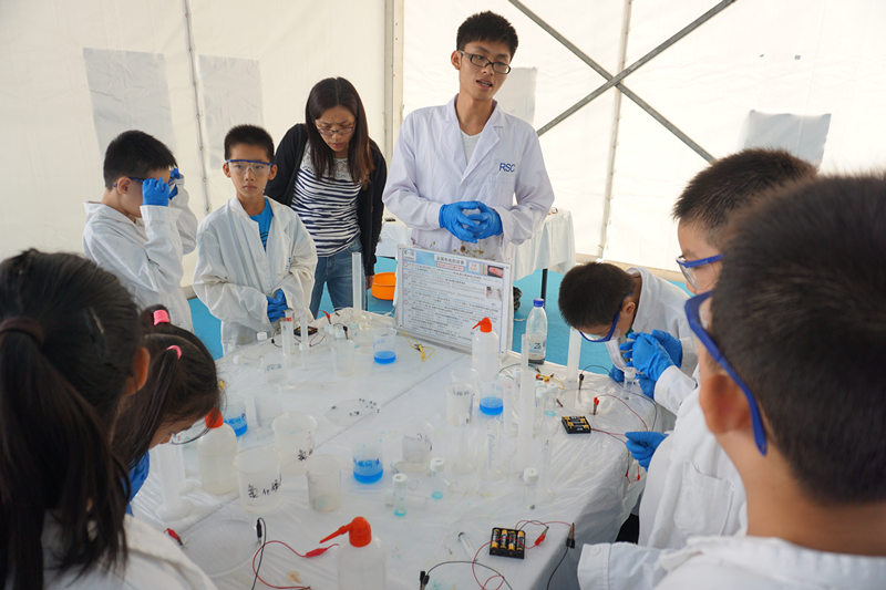 北京化工大學的同學正帶領孩子們做實驗。