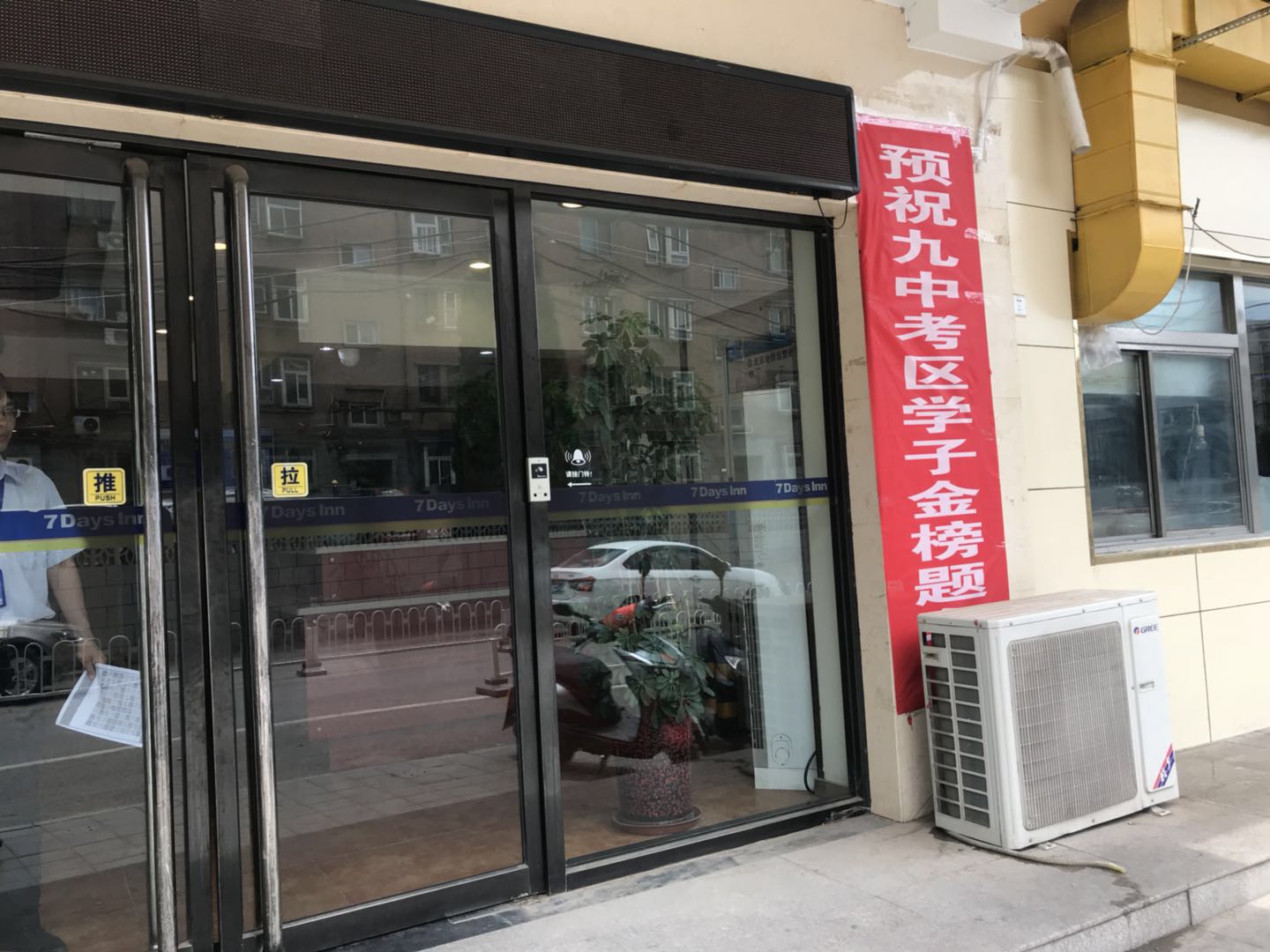 通向北京九中考點的居民區裡，一家連鎖酒店門前挂出了“預祝九中考區學子金榜題名的”紅色條幅。