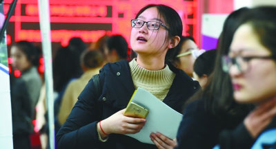 3月10日，江苏省2018年女大学毕业生专场招聘会在南京举行。图为一位女大学生在招聘会上寻找就业岗位。新华社记者 孙参摄