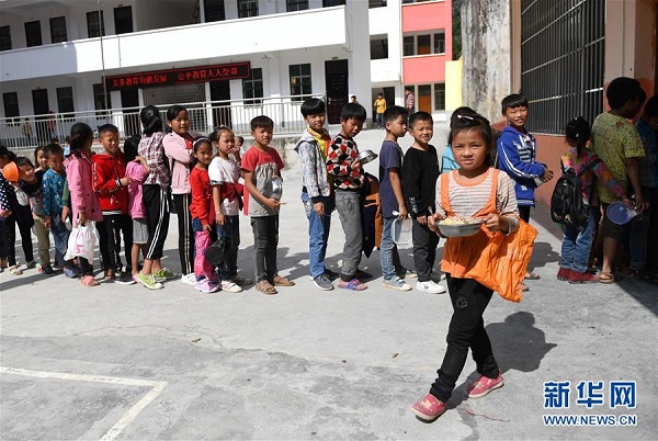 在广西都安瑶族自治县下坳镇隆麻小学，学生排队领取营养午餐（11月6日摄）。
