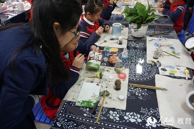 瓷板畫2008年入選國家級非物質文化遺產名錄。碟子湖學校由專業老師指導學生在筆筒、水杯上作畫。何淼攝