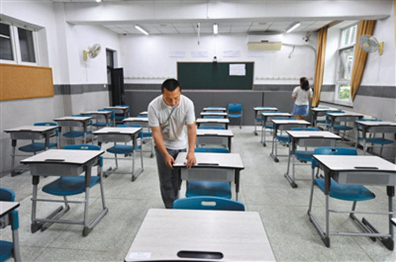6月6日，北京一零一中学考点，监考老师在考场贴桌签。李木易/摄