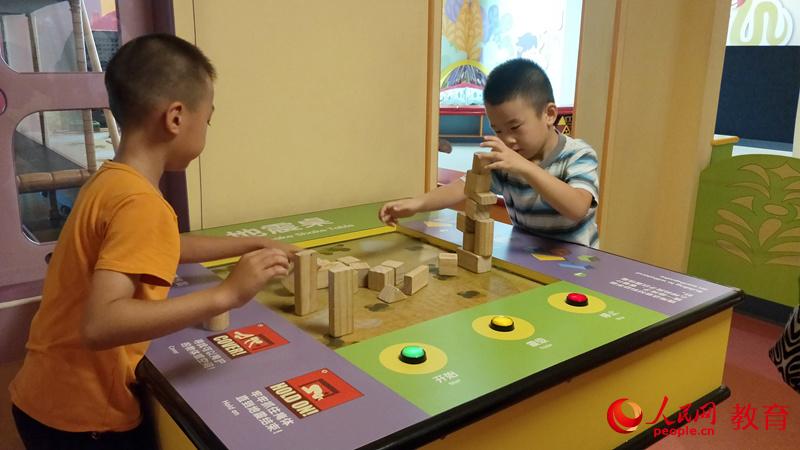 圖為孩子在中國兒童中心體驗地震桌項目 王子文/攝