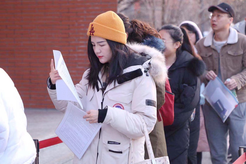 12月21日，北京第二外国语学院考点，排队入场时复习的考生（唐文清/摄）