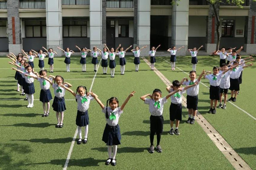 虹口区第三中心小学学生们站在操场上围成一个爱心。（来源：上海教育微信公众号）