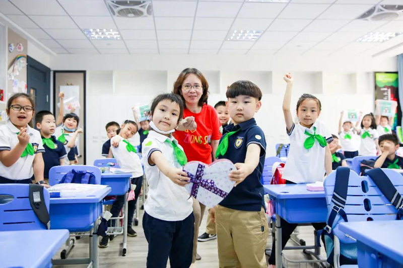 黄浦区教育学院附属中山学校学生们和老师一起对着镜头比心。（来源：上海教育微信公众号）