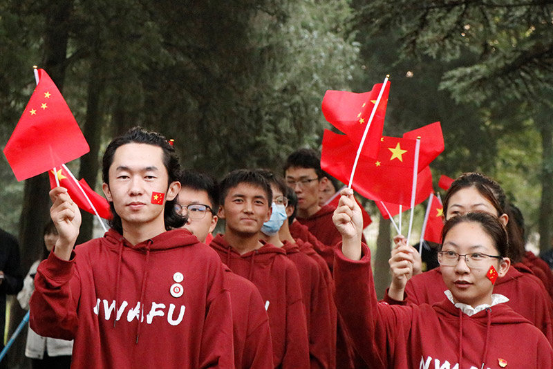 西北农林科技大学的同学们挥舞着红旗，他们心中有光。葛舒悦摄