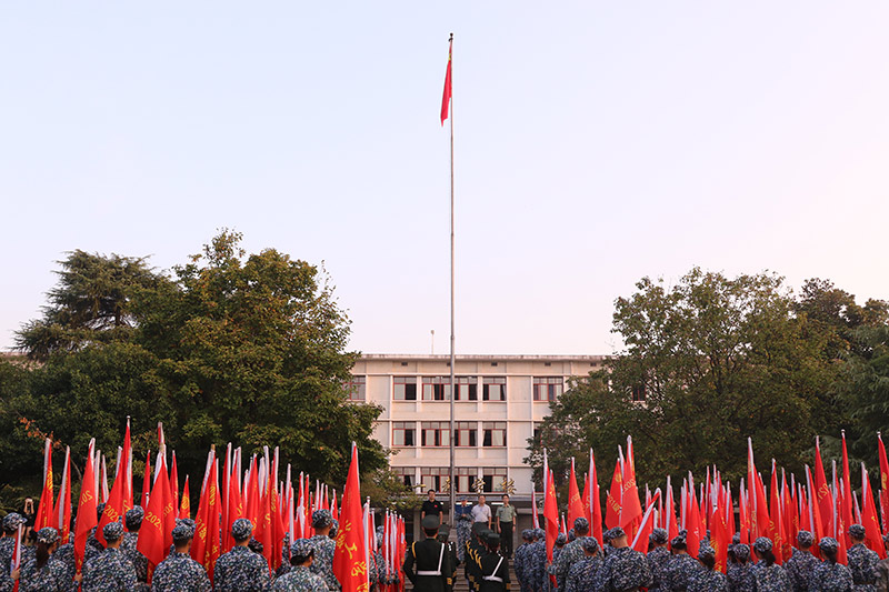 湘潭大学200余名新生代表身着迷彩服，在第一教学楼前坪参加国庆升旗仪式。学校供图