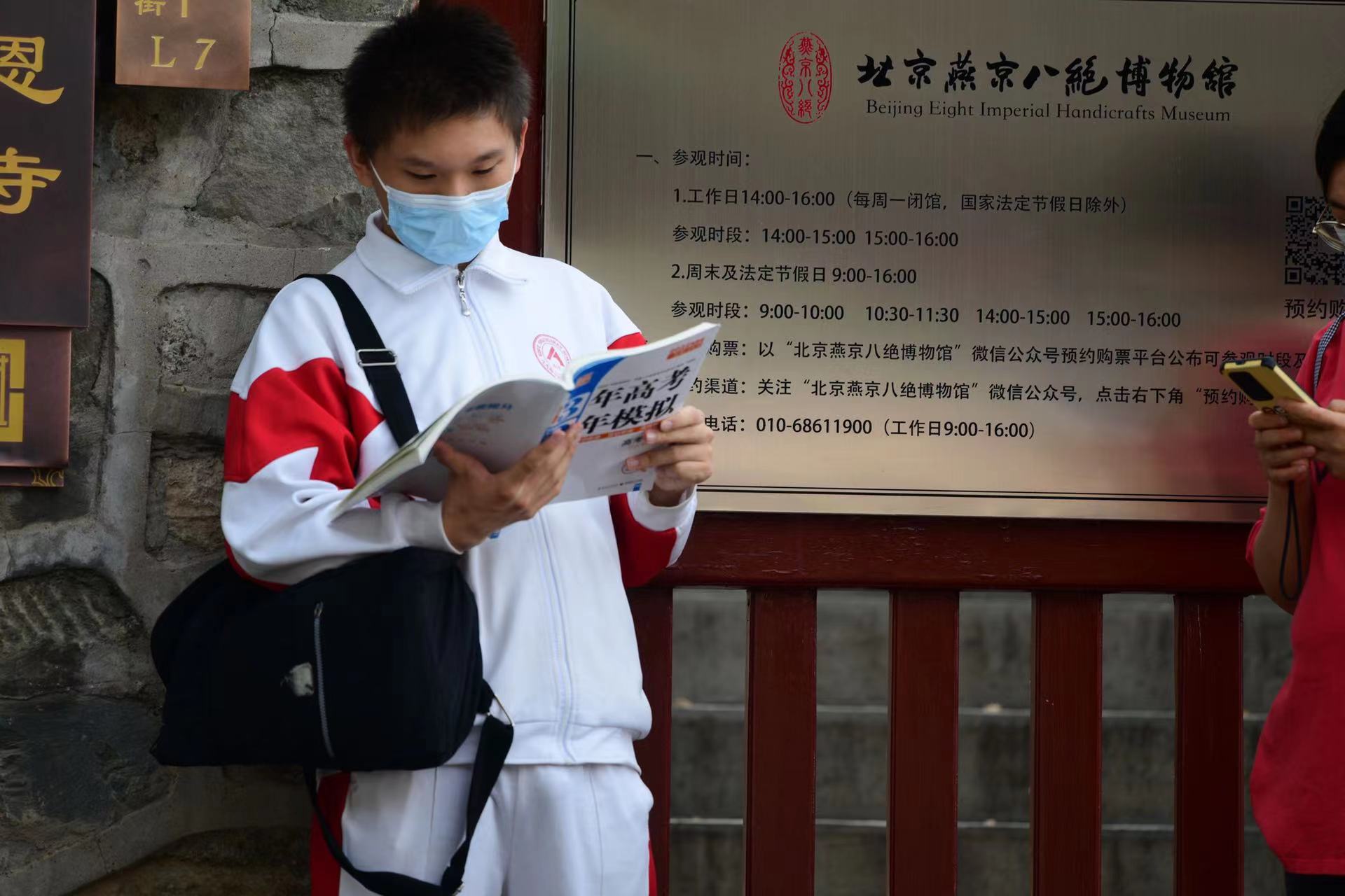 6月7日，在北京市第九中學考點外，考生抓緊時間復習。當日，2022年北京市高考開考，4.8萬余考生走入考場。人民網記者 于凱攝