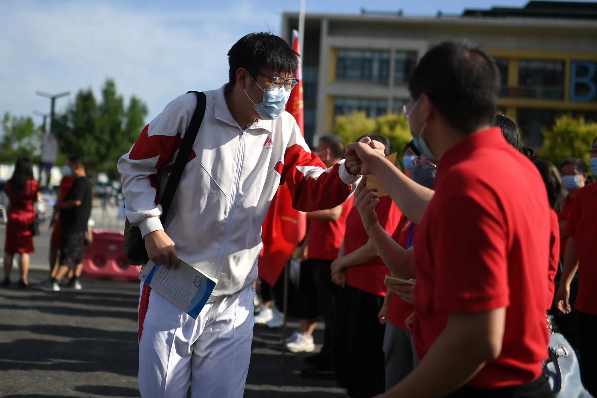 6月7日，在北京市人大附中通州校區考點，考生與送考老師擊拳加油。當日，2022年北京市高考開考，4.8萬余考生走入考場。人民網記者 翁奇羽攝