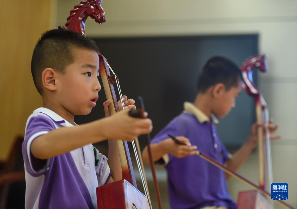 6月24日，在包头市昆都仑区包钢第十七小学，学生们在学习马头琴。