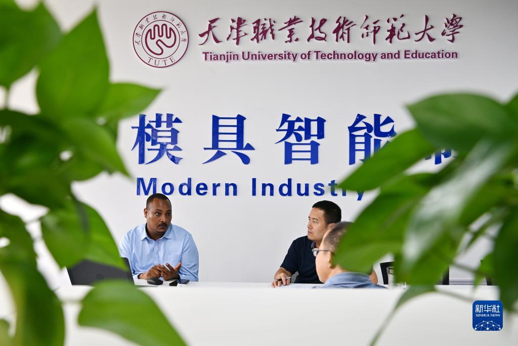 在天津職業技術師范大學，韓士蘭（左一）和老師們交流（8月12日攝）。新華社記者李然攝
