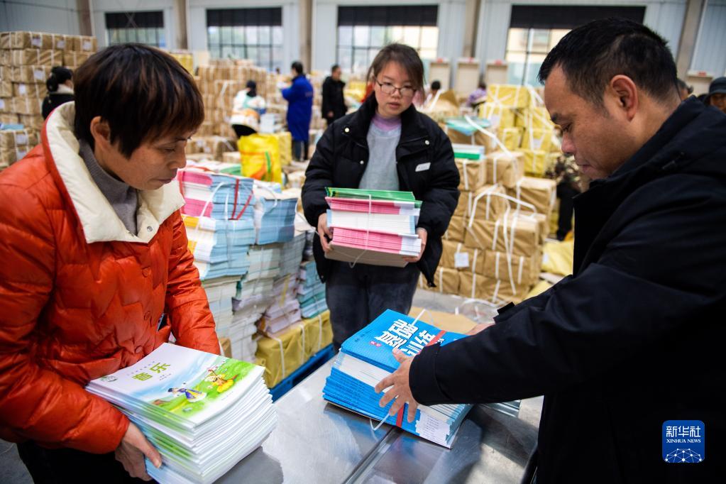 2月4日，在祁陽市新華書店教材中轉庫，工作人員在打捆教材。