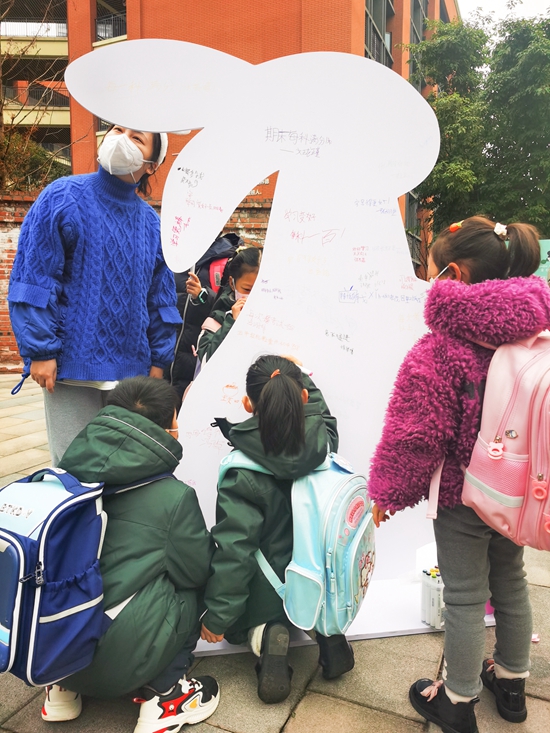 2月6日，重慶兩江新區童心青禾小學，小學生在兔子造型的留言板上，寫下新學期的願望。鄒樂 攝