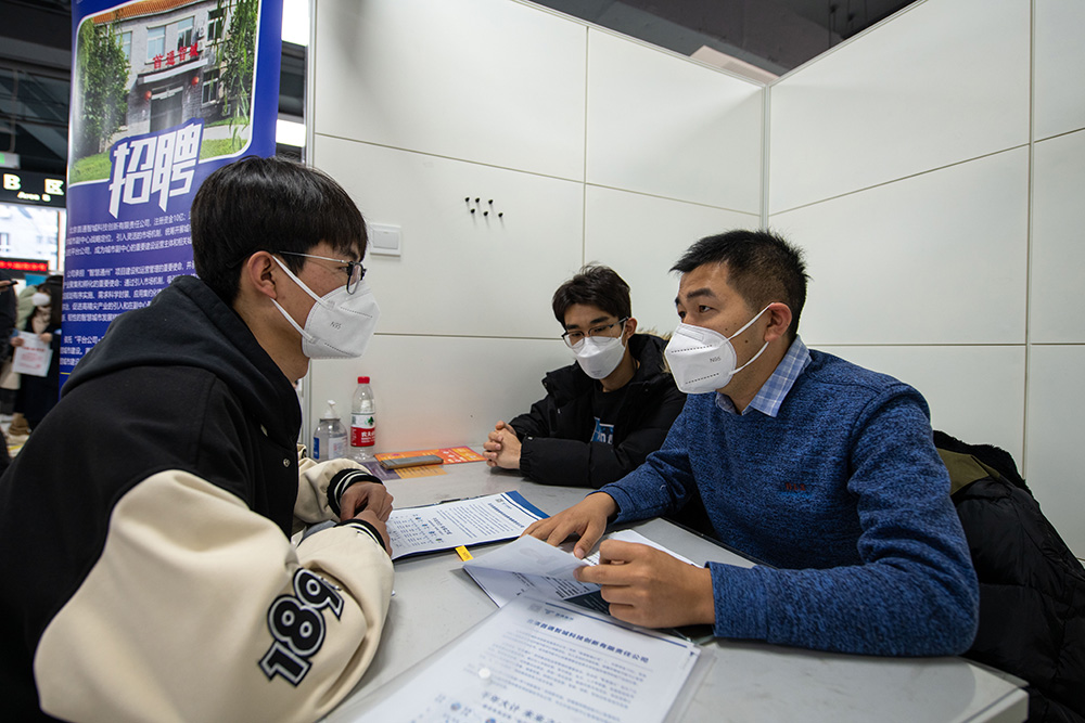 2月8日，求職學生（左一）與招聘單位代表交流。人民網記者 翁奇羽攝