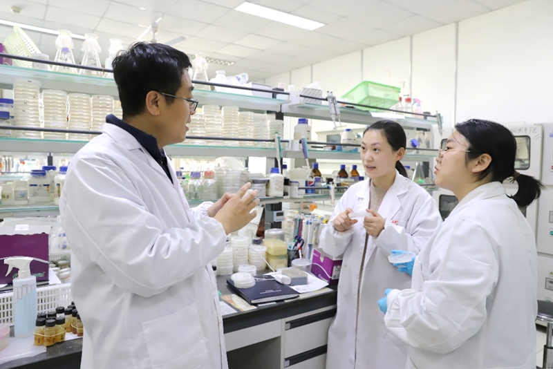 山東大學：開學日，學校微生物技術國家重點實驗室陳林旭教授和學生在交流實驗。校方供圖