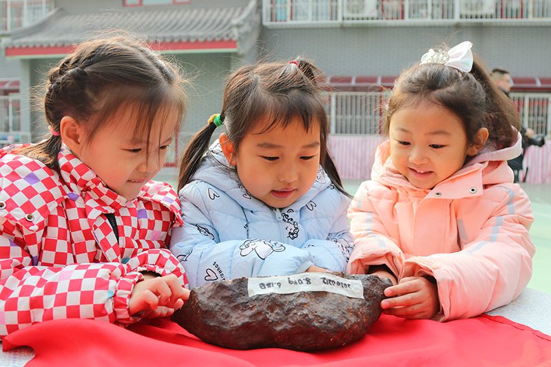在北京市第一幼兒園吉祥魏家分園舉行第九屆“科學節”活動上，小朋友們正在觀察隕石。校方供圖