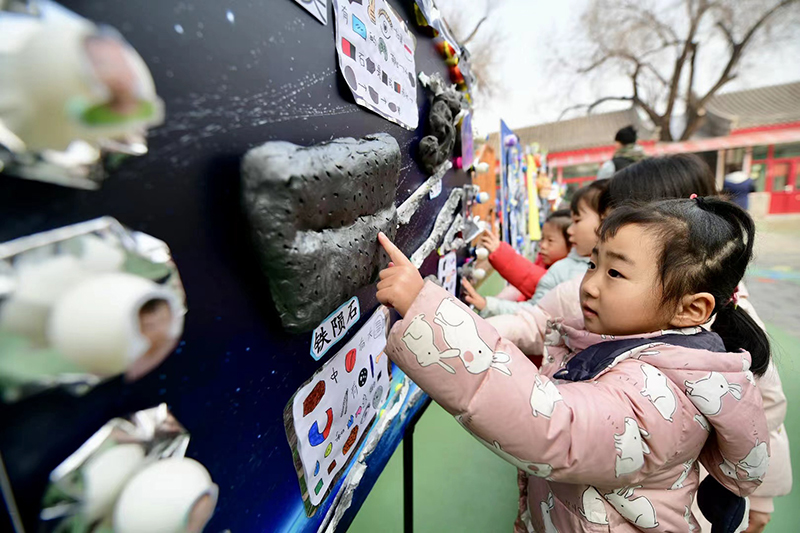 在北京市第一幼兒園吉祥魏家分園舉行第九屆“科學節”活動上，小朋友們正在觀察隕石。校方供圖