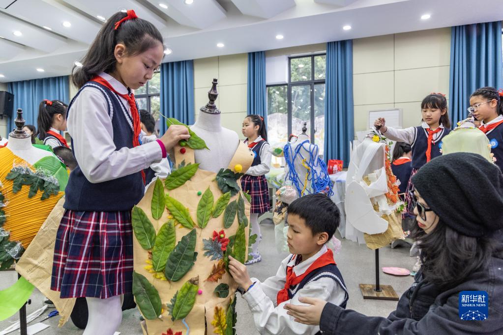 3月10日，重庆市九龙坡区铁路小学的学生们在老师的指导下制作环保服装。