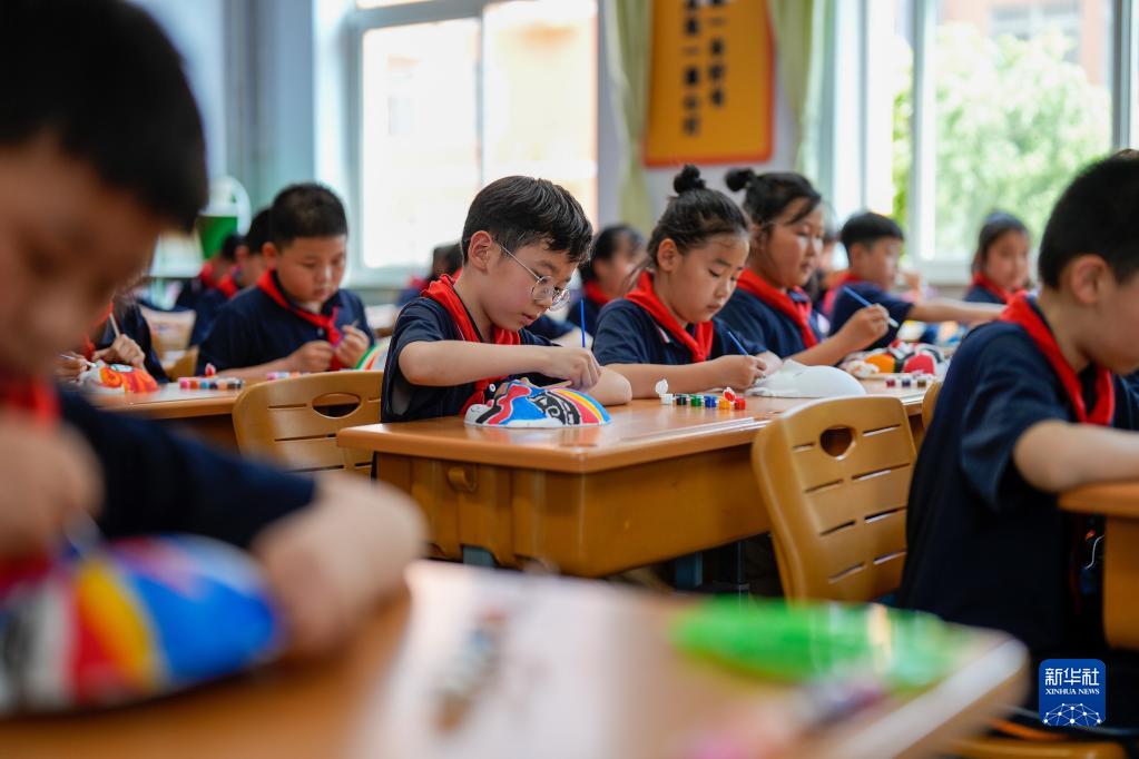 5月19日，河北省滦南县第一实验小学手工社团的学生在给京剧脸谱上色。