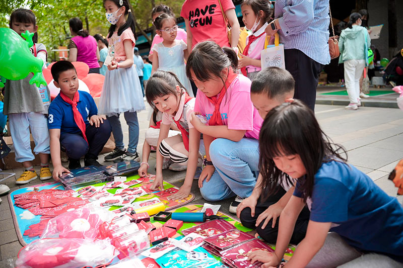 “爱心市集”上儿童通过摆摊、义卖的方式，售卖爱心商品，获得爱心善款参与“苔花绽放”事实无人抚养儿童关爱行动。中国儿童中心供图