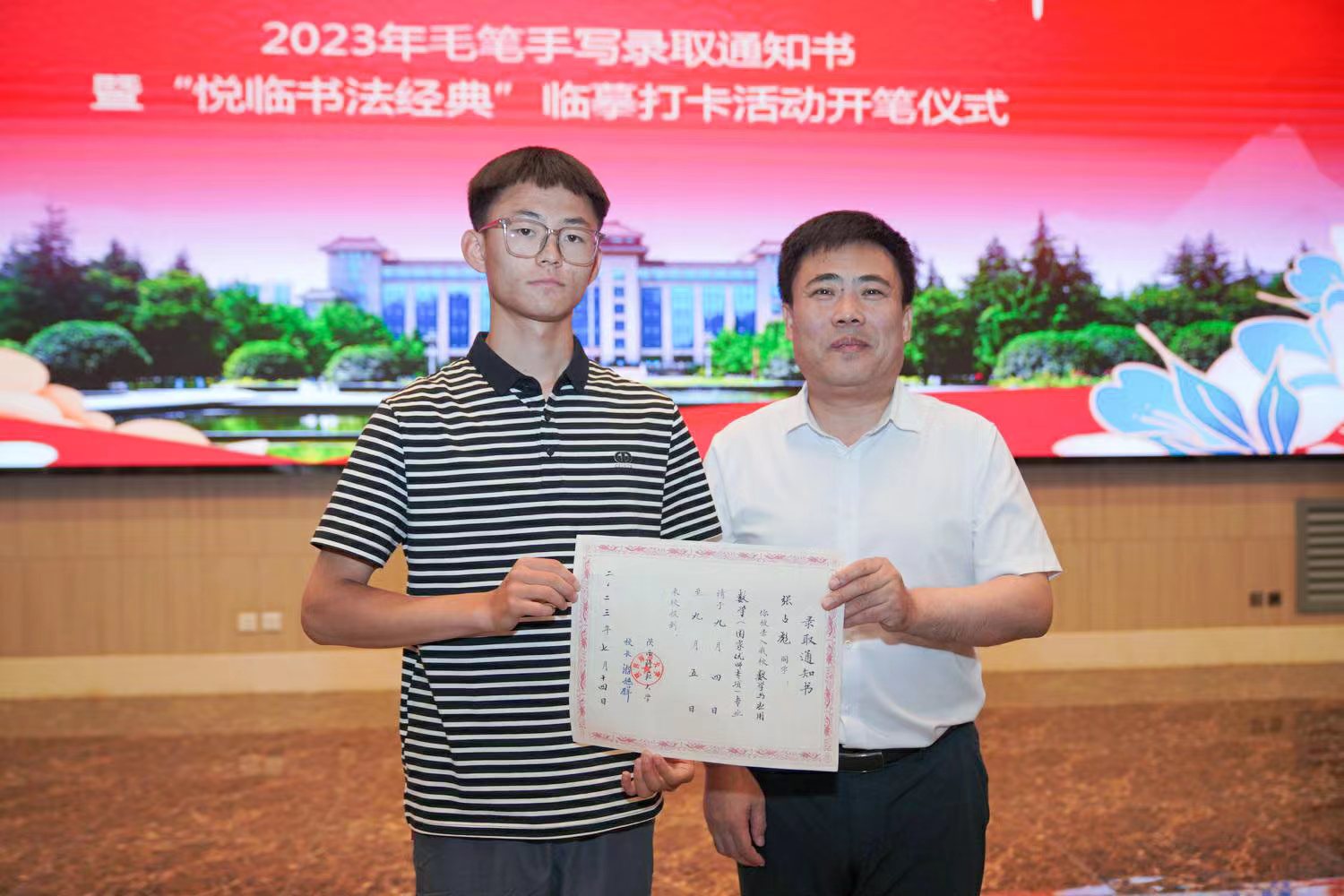 陝西師范大學黨委書記李忠軍為2023級新生代表張佔彪同學發放錄取通知書。校方供圖