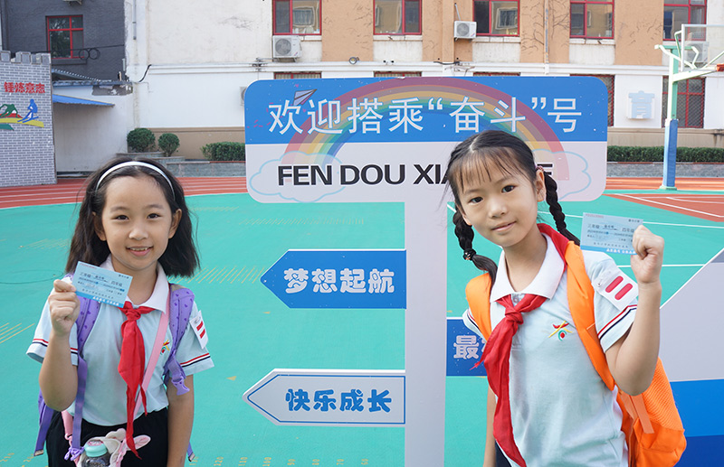 9月1日，北京市西城区奋斗小学的师生们迎来了新的学期。校园内放置的“奋斗号”火车造型，车厢设计对应各年级，并在车门处安排投票口供学生投入车票。图为学生们手持车票，准备踏上“奋斗号”火车，开启新的旅程。