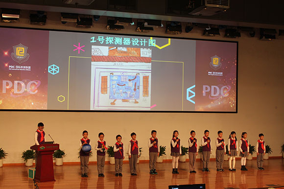 北京呼家楼中心小学的学生们展示PDC项目“新行星移民计划探索卫星设计”。