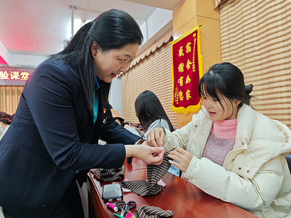 学生在老师指导下，体验缝补收纳。