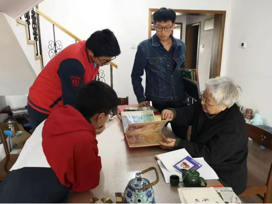 2019年，岳同給來家看望的志願者們展示收藏的剪紙、中國畫作品。中國人民大學供圖