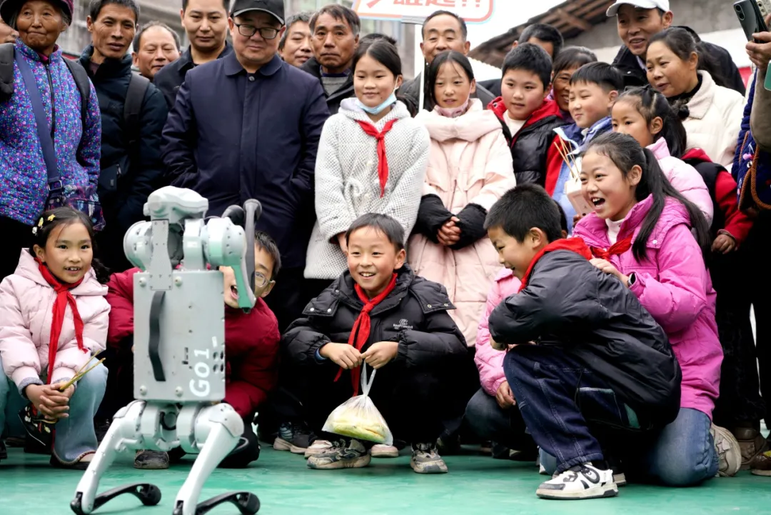 2025年12月6日,四川省巴中市通江縣勝利鄉新時代文明實踐所,學生們與機器狗開展一場別開生面的“人機互動”活動。 程聰 攝