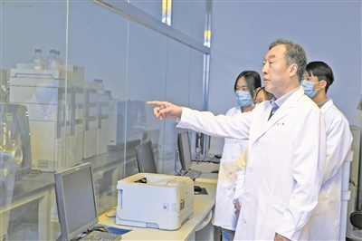 崔一民(右二)在质谱施行室指导学生开展施行。 受访者供图