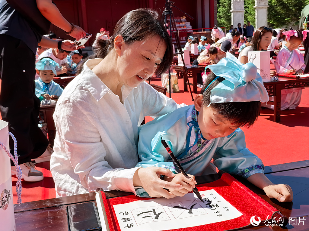 2026年5月30日，在吉林長春文廟博物館傳統啟蒙禮活動現場，孩子們提筆書寫“仁”與“人”，在古韻雅樂中篤學明禮，開啟嶄新的成長篇章。人民網記者 王帝元攝