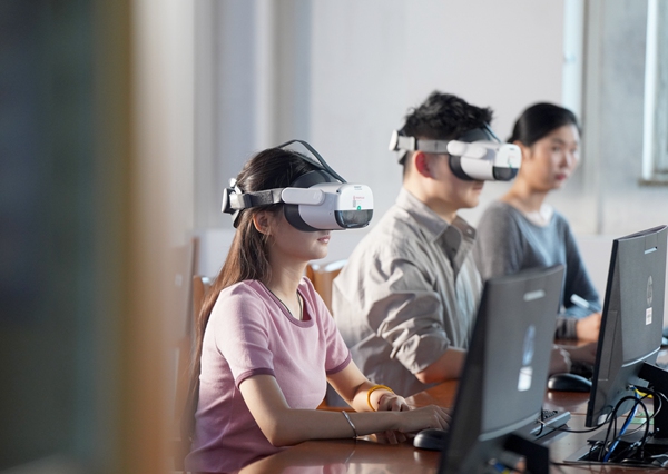 首经贸大学生使用VR设备进行学习场景交互体验。