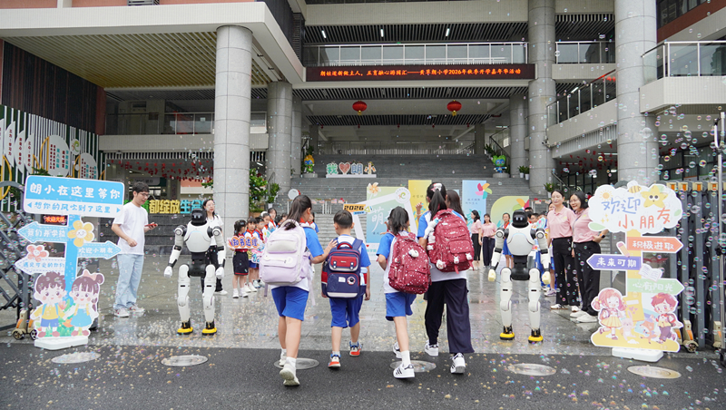 东莞市大朗镇黄草朗小学校门口机器人和孩子们击掌问好。校方供图