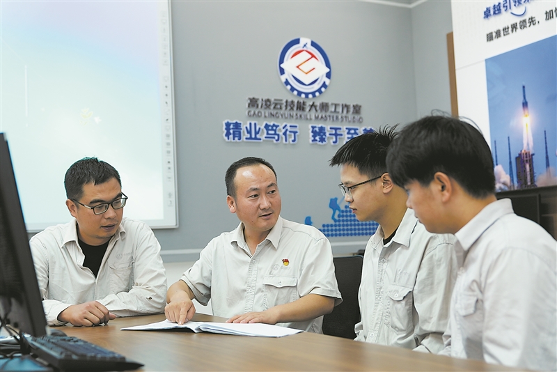 高凌云（左二）与团队成员在工作室交流工作。 受访单位供图