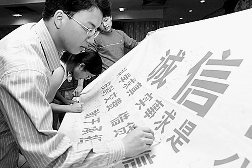 高校全面參與國家助學貸款的管理,克服了銀行在后續管理上存在的嚴重“脫節”的問題,有效防范和控制了風險。圖為大學生在助學貸款誠信宣言上簽名。資料照片