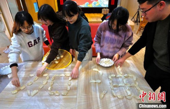 师生们将包好的饺子拼成“加油”字样。　泱波 摄