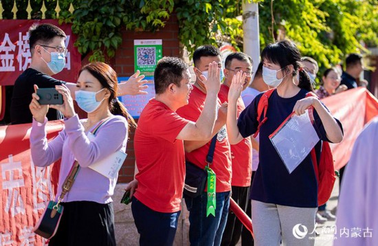內蒙古自治區呼和浩特市第六中學考點，考生進入考場前與老師擊掌。丁根厚攝