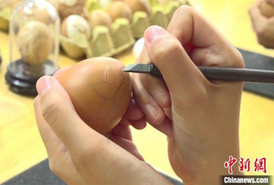 圖為學生們用刻刀在蛋殼上雕刻圖案。　劉玉桃 攝