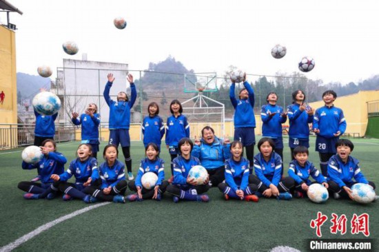 圖為12月9日，“元寶女子足球隊”教練徐召偉(中)和部分隊員合影。　瞿宏倫 攝
