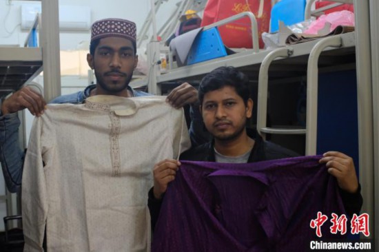 图为两名孟加拉国留学生展示自己从行李箱拿出的传统服饰。　李娇阳 摄