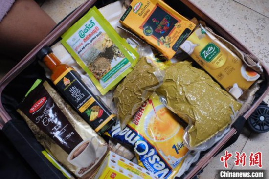 图为一名斯里兰卡留学生的行李箱中装满美味食物。　刘俊聪 摄