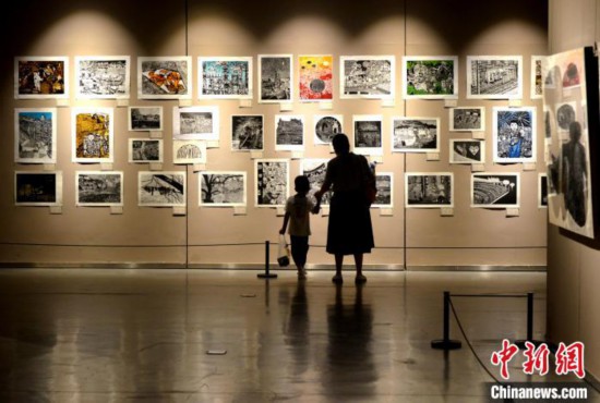 图为家长带着孩子参观展览。　吕明 摄